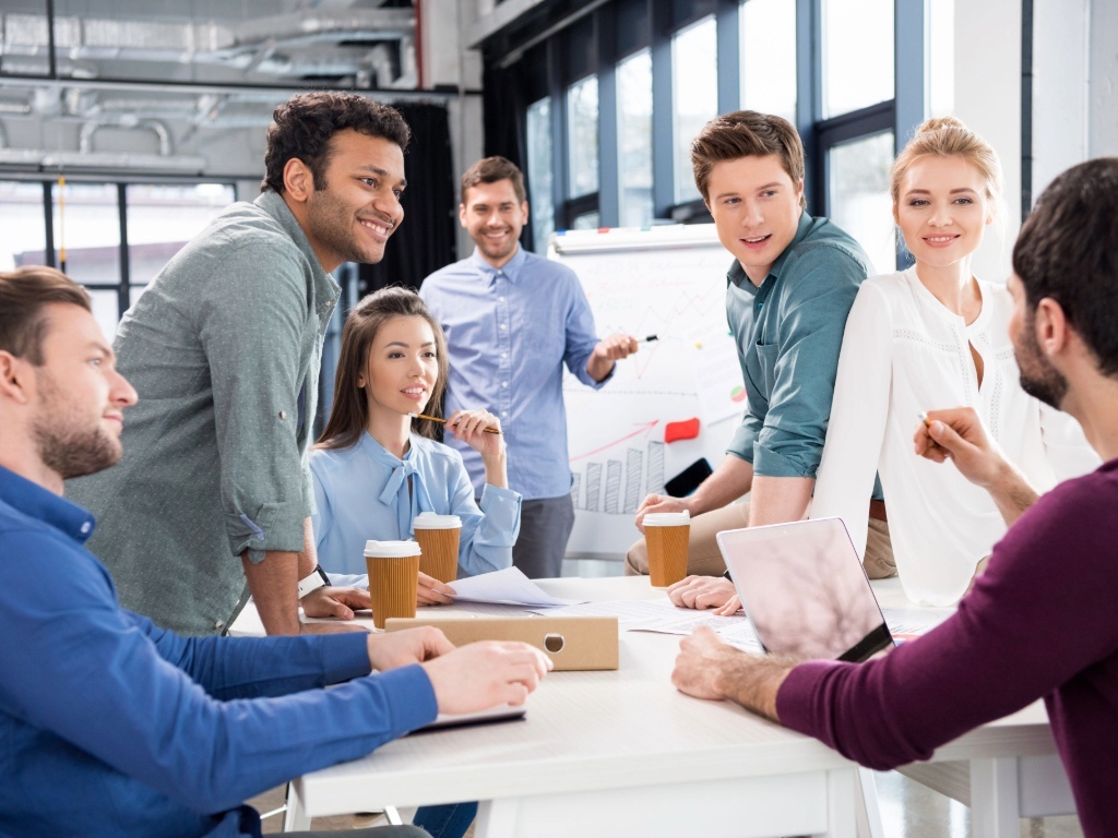 Equipo de profesionales colaborando y conversando, haciendo team building en la empresa.