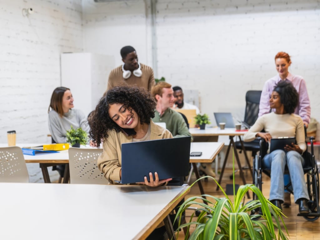 Equipo de trabajo colaborando en la oficina para prevenir el síndrome postvacacional.